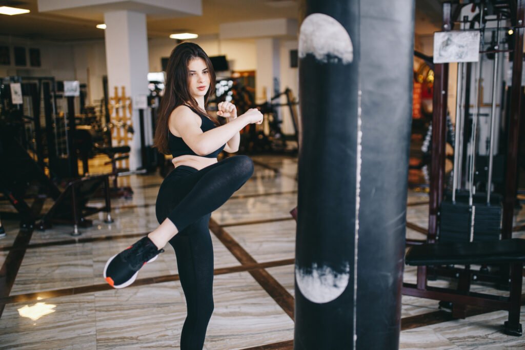 Beautiful girl in the gym. A woman performs exercises. The girl is boxing