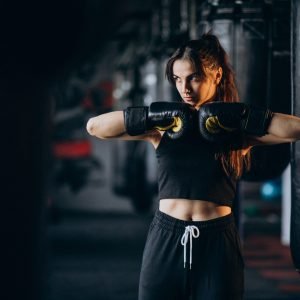 Young woman boxer training at the gym